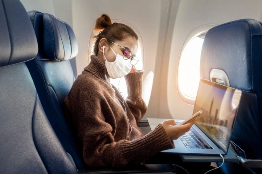 A,Young,Woman,Wearing,Face,Mask,Is,Traveling,On,Airplane