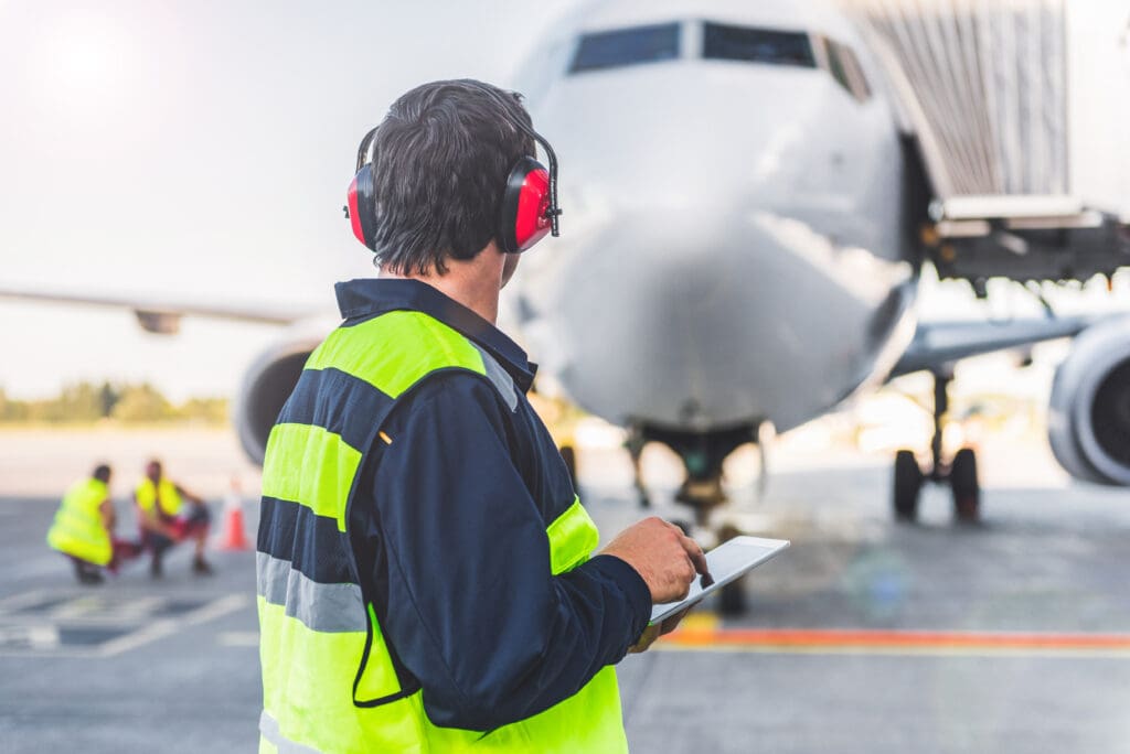 Male,Worker,Controlling,Aircraft,And,Writing,Information