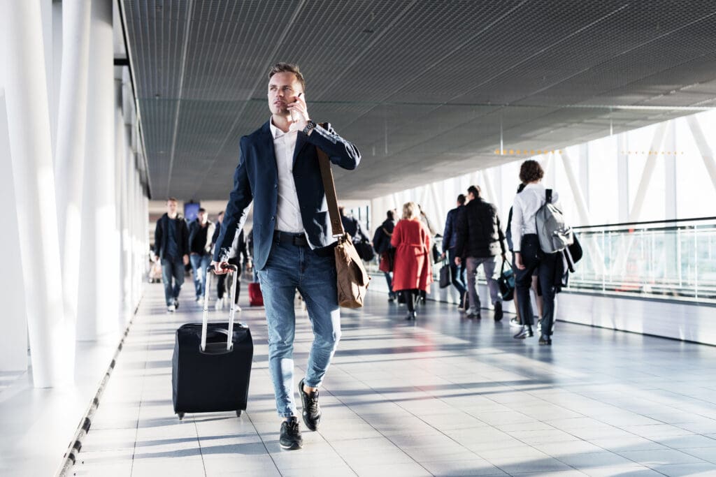 Busy,Man,Speaking,On,Phone,And,Walking,In,Airport