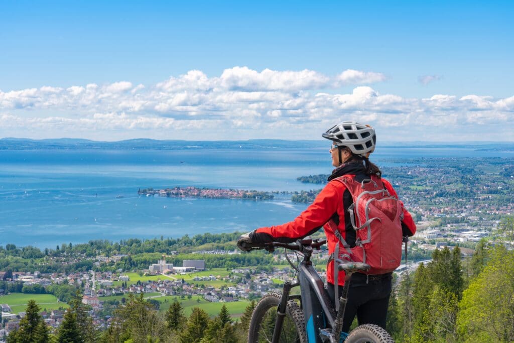 Happy,,Active,Senior,Woman,Cycling,Above,Lake,Constance,,Bodensee,And