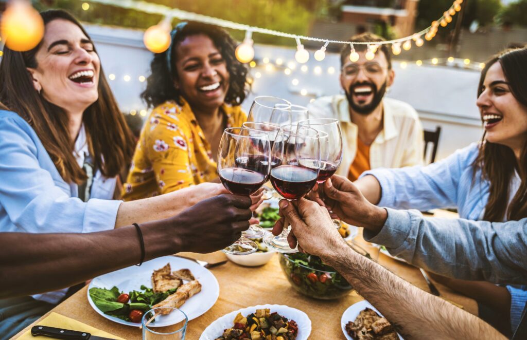 People,Toasting,Red,Wine,Glasses,On,Rooftop,Dinner,Party,-