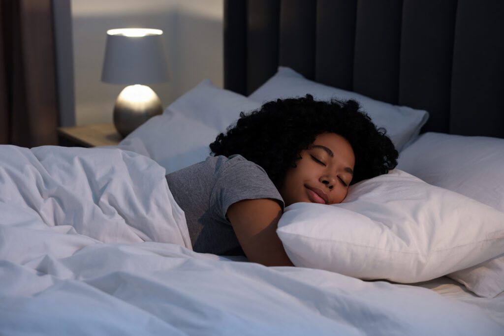 Young woman sleeping in soft bed at night