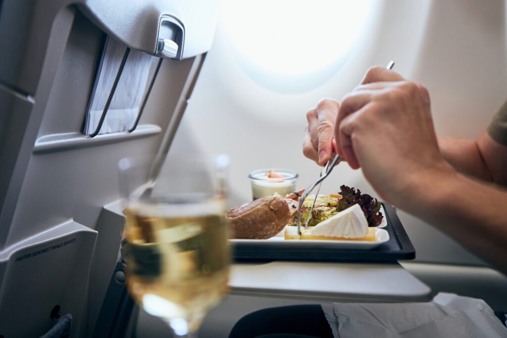 Airline,Meal,And,Beverage,Served,On,Seat,Tables,During,Flight.